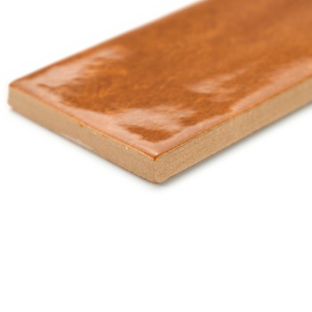 Eine rechteckige, glänzende, braune Fliese liegt mit sichtbarer Kante vor einem weißen Hintergrund und hebt ihre glatte, glänzen