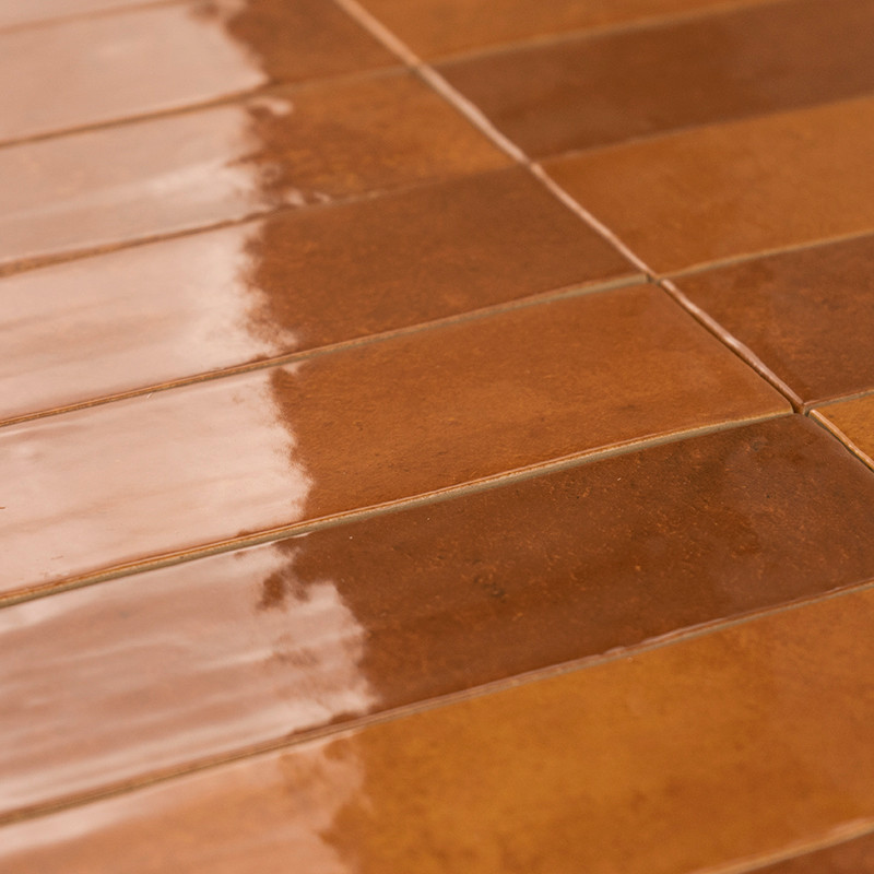 Rectangular brown tiles lie adjacent, reflecting light on a glossy surface, arranged in horizontal rows, creating a warm, unifor