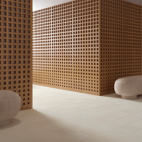 Eine Holzgitterwand unterteilt einen Raum, der mit beigen Bodenfliesen und abgerundeten grauen Ottomanen geschmückt ist. Der Rau