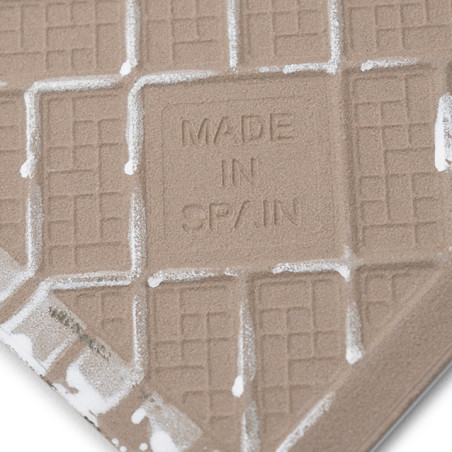 Eine strukturierte Fliese weist geprägte Gittermuster und den Text „MADE IN SPAIN“ in der Mitte auf, umgeben von weißen Rändern. Eine strukturierte Fliese weist geprägte Gittermuster und den Text „MADE IN SPAIN“ in der Mitte auf, umgeben von weißen Rändern.