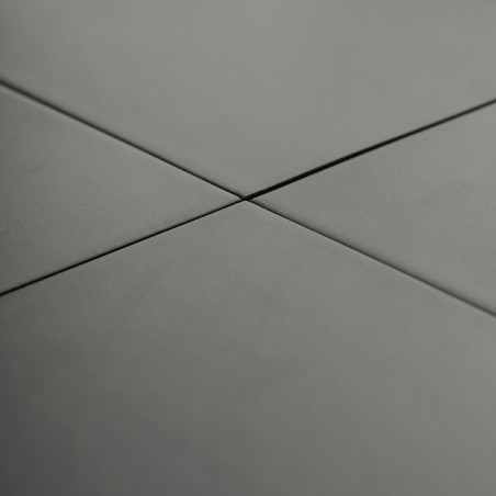 Graue Keramikfliesen überschneiden sich im rechten Winkel und bilden ein Kreuzmuster in einer glatten, gleichmäßig beleuchteten 