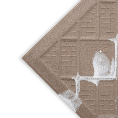 Um ladrilho marrom apresenta um padrão de grade texturizado com salpicos de tinta branca, com a inscrição "MADE IN SPAIN", situa Um ladrilho marrom apresenta um padrão de grade texturizado com salpicos de tinta branca, com a inscrição "MADE IN SPAIN", situa