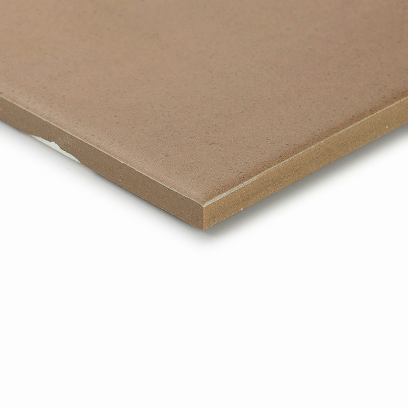 A brown ceramic tile with a smooth surface and sharp edges sits against a plain white background, highlighting its simplicity.