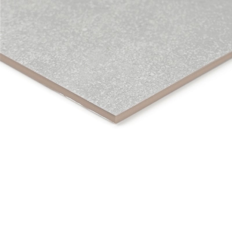 A close-up shows a rectangular, gray ceramic tile with a matte finish, resting on a flat white surface.