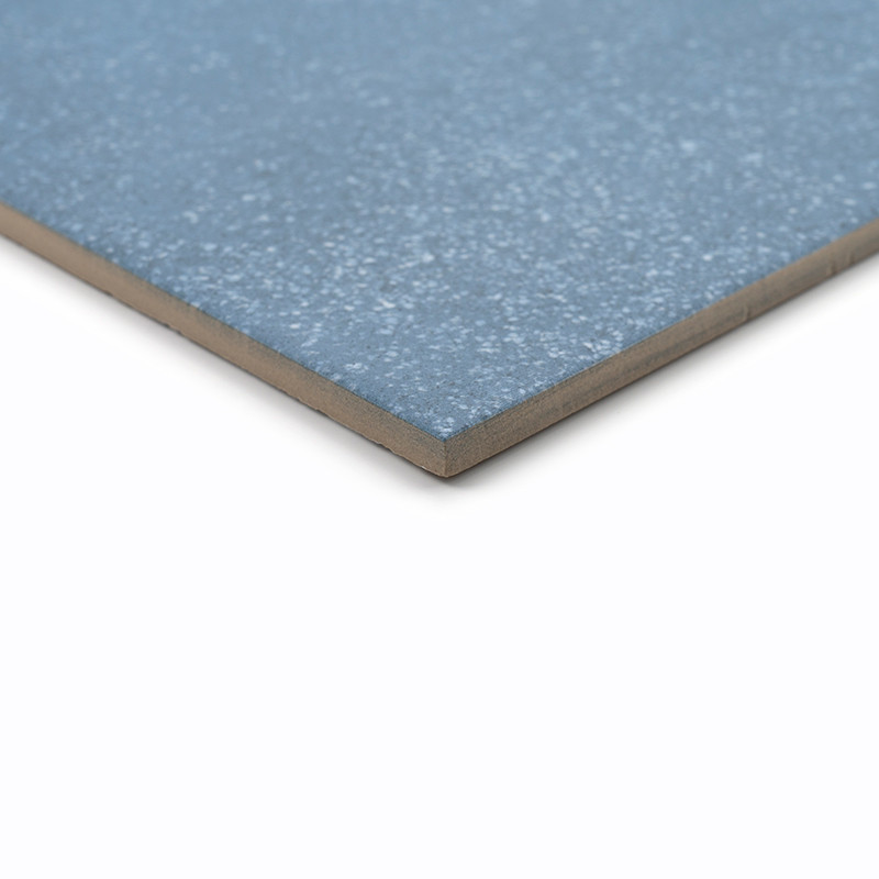 Um ladrilho cerâmico azul, plano, apresenta uma textura manchada em sua superfície lisa contra um fundo branco liso.