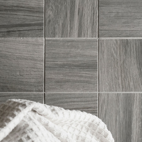 Les carreaux gris avec une texture semblable à celle du bois sont disposés selon un motif en grille. une serviette gaufrée blanc Les carreaux gris avec une texture semblable à celle du bois sont disposés selon un motif en grille. une serviette gaufrée blanc