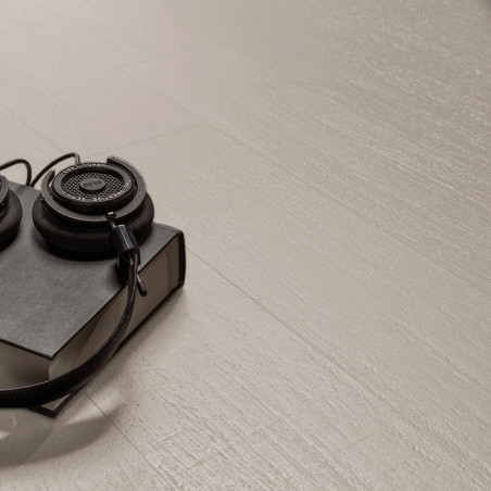 Kopfhörer ruhen auf einem geschlossenen schwarzen Buch, das auf einem strukturierten, hellen Boden oder einer Fliese platziert i