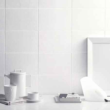 Witte keramische tegels vormen een gestructureerde muur, vergezeld van een minimalistische opstelling van een theepot, kopje, fr Witte keramische tegels vormen een gestructureerde muur, vergezeld van een minimalistische opstelling van een theepot, kopje, fr