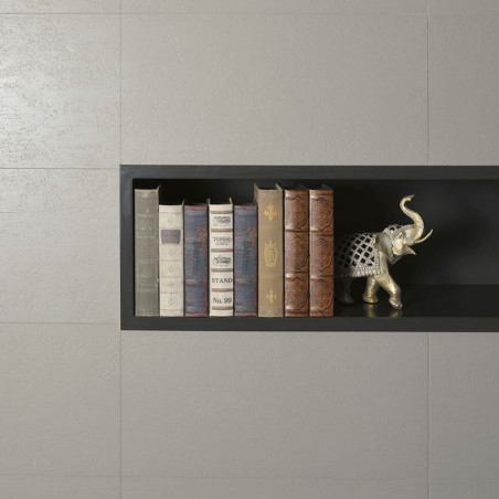 Uma prateleira preta embutida contém seis livros empilhados verticalmente e uma estatueta decorativa de elefante prateado, coloc Uma prateleira preta embutida contém seis livros empilhados verticalmente e uma estatueta decorativa de elefante prateado, coloc
