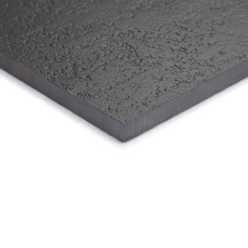 Un carreau texturé gris foncé avec une surface légèrement rugueuse repose à plat sur un fond blanc, affichant son épaisseur et s