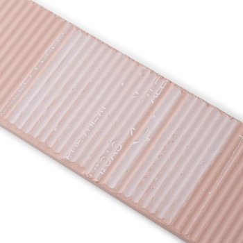 A rectangular, beige ceramic tile features a ribbed texture and indented text reading `TILE LINES,` with a glossy finish, set on