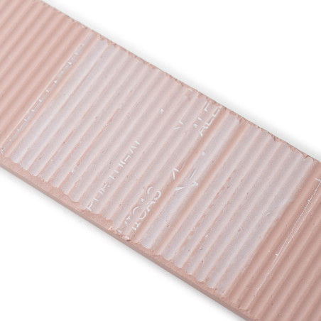 A rectangular, beige ceramic tile features a ribbed texture and indented text reading `TILE LINES,` with a glossy finish, set on A rectangular, beige ceramic tile features a ribbed texture and indented text reading `TILE LINES,` with a glossy finish, set on