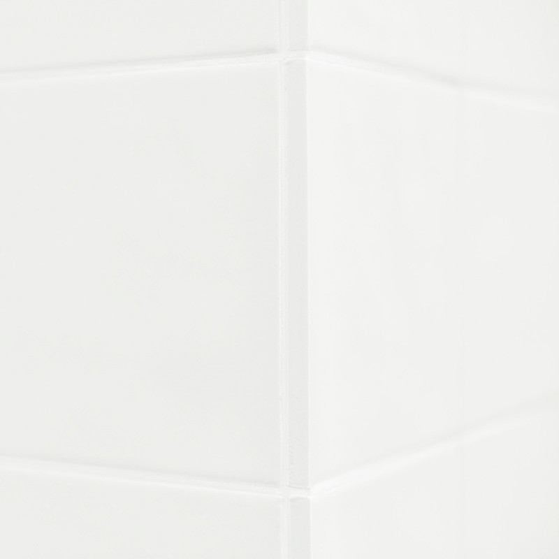 White ceramic tiles form a clean corner, reflecting light subtly. The smooth surface suggests a bathroom or kitchen setting.