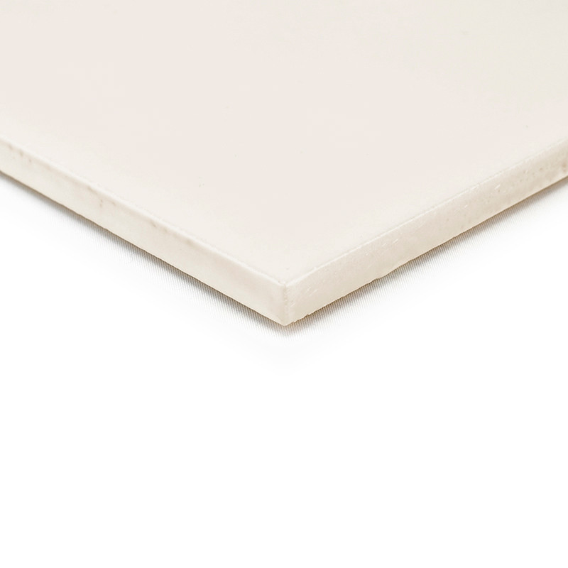 Un azulejo de cerámica beige descansa plana con un acabado suave y mate, con bordes afilados sobre un fondo blanco liso.