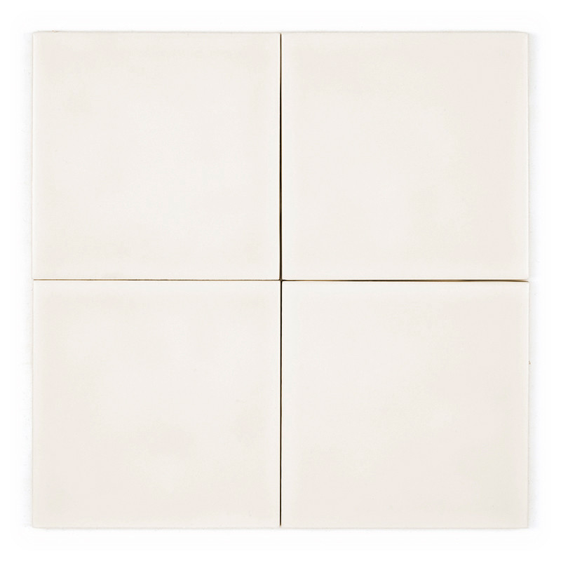 Quatre carreaux carrés blanc cassé sont disposés côte à côte dans un carré plus grand, séparés par de fines lignes de coulis.
