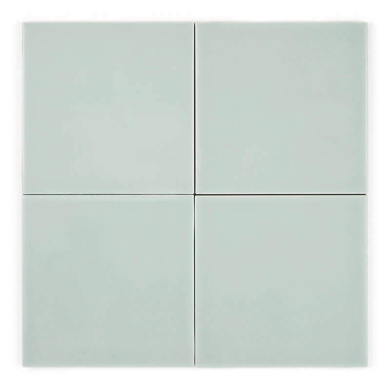 Four light green square tiles are arranged in a 2x2 grid, forming a simple, symmetrical pattern on a plain background.