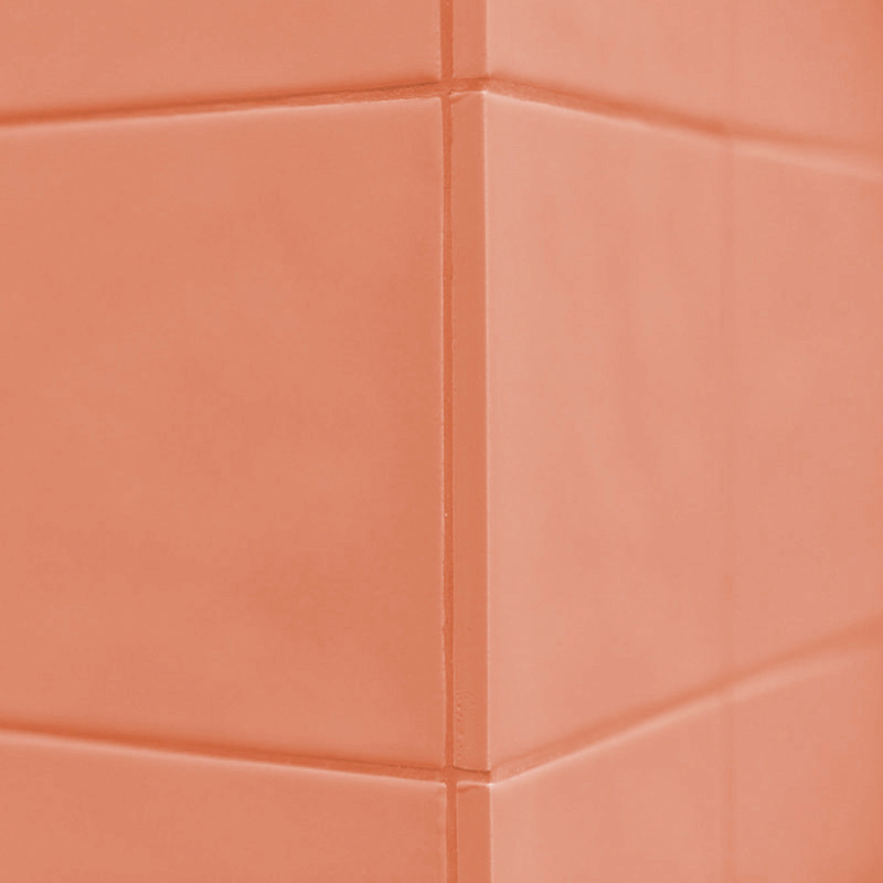 Les carreaux orange forment un coin à angle droit, créant une surface homogène. Le contexte est un décor mural intérieur simple.