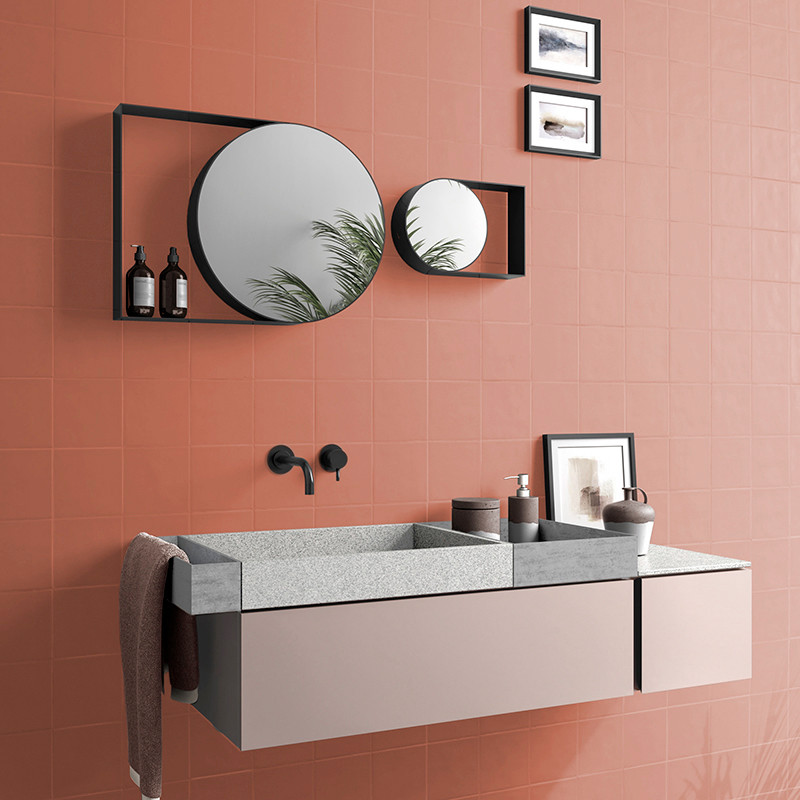 A modern bathroom features a floating vanity with a rectangular sink, circular mirrors reflecting greenery, and dark fixtures ag