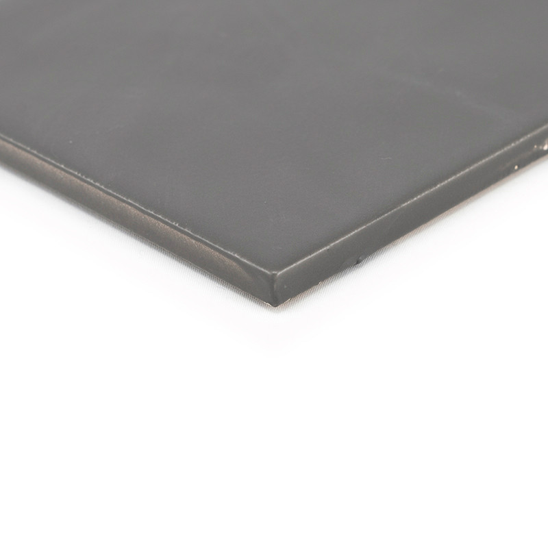 Una losa lisa de color gris oscuro yace plana, sus bordes ligeramente biselados insinúan durabilidad, sobre un fondo blanco liso