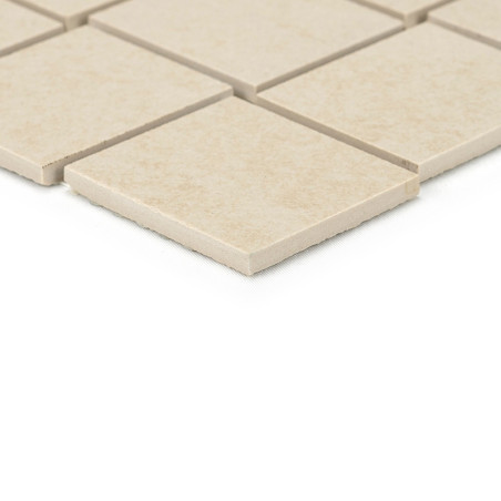 Beige, vierkante keramische tegels uitgelijnd in een rasterpatroon, met strakke randen. ze rusten op een vlak, lichtgekleurd opp