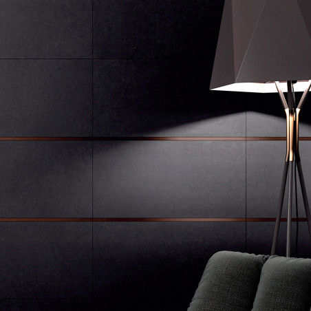 Uma luminária de chão preta ilumina uma parede escura de azulejos com finas linhas horizontais. Uma poltrona texturizada aparece Uma luminária de chão preta ilumina uma parede escura de azulejos com finas linhas horizontais. Uma poltrona texturizada aparece