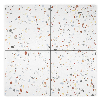 A white ceramic tile displays scattered, colorful specks in red, blue, gray, yellow, and black, creating a terrazzo pattern.