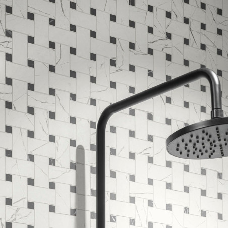 De douchekop steekt uit een pijp en loopt schuin over een muur bedekt met een geometrisch mandenpatroon van grijze en witte tege De douchekop steekt uit een pijp en loopt schuin over een muur bedekt met een geometrisch mandenpatroon van grijze en witte tege