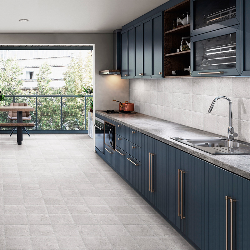 Una cocina moderna cuenta con gabinetes azules con elegantes manijas, un protector contra salpicaduras de azulejos grises y una 