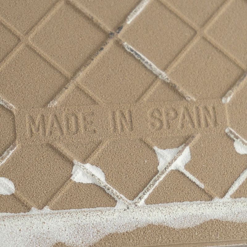 Le carreau de céramique beige comporte le texte en relief « MADE IN SPAIN », affichant un motif en losange avec des taches blanc