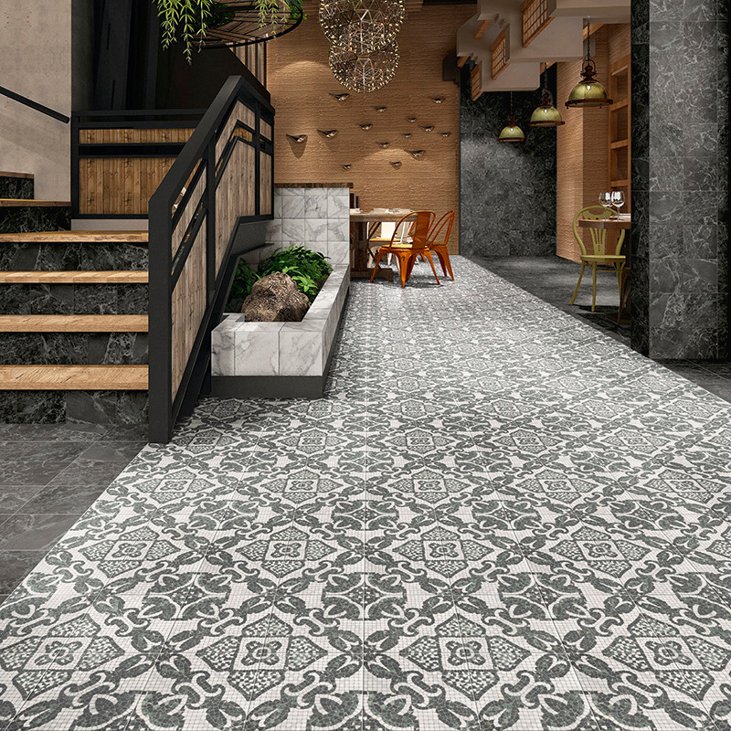 Azulejos con diseños intrincados cubren el piso y conducen a un área de comedor en un interior moderno y cálidamente iluminado c