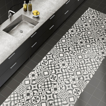 Os pisos estampados apresentam desenhos geométricos em preto e branco, adicionando contraste a uma cozinha com bancada cinza e p