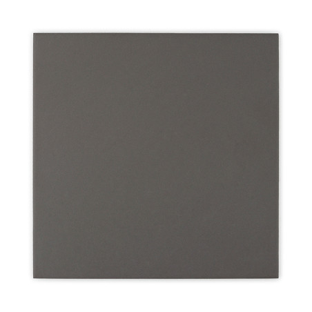 Um ladrilho quadrado escuro e de cor sólida apoiado sobre um fundo branco liso. Um ladrilho quadrado escuro e de cor sólida apoiado sobre um fundo branco liso.