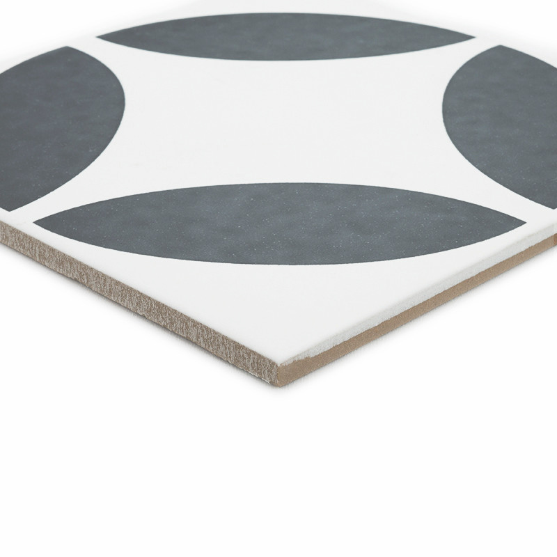 Un azulejo cerámico cuadrada presenta un patrón de cuatro cuartos de círculo de color gris oscuro sobre un fondo blanco, formand