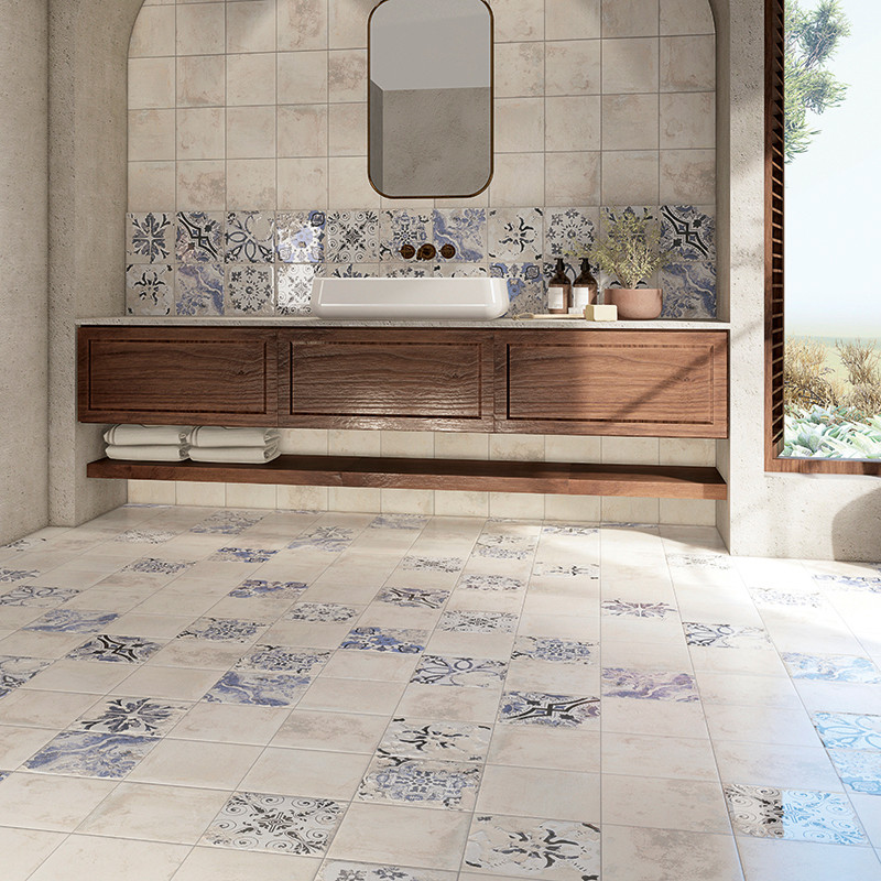 Ein Badezimmer verfügt über gemusterte Fliesen mit Blumenmotiven, die den Boden und einen Teil der Wand bedecken. Auf einem hölz