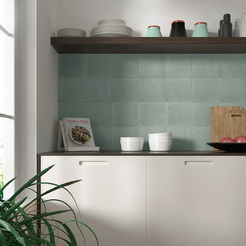 A kitchen countertop displays white bowls and a cookbook titled `Healthy Mind` against a backdrop of light green tiles. Shelves 