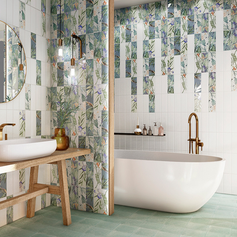 Ein Badezimmer verfügt über eine weiße freistehende Badewanne unter einem Messinghahn. Fliesen mit Blumenmuster und ein Holzwasc