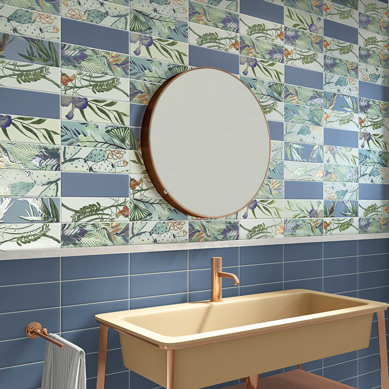 Une salle de bains moderne comprend un miroir rond et un lavabo beige avec un robinet en or rose, sur fond de carrelage bleu et 