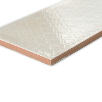 Diagonal liegt eine rechteckige Keramikfliese mit glänzender Rautenmusteroberfläche. An seinen Rändern liegt ein rotbrauner Tong