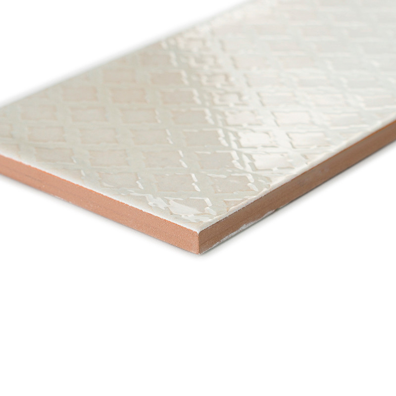 A rectangular ceramic tile rests diagonally, featuring a glossy, diamond-patterned surface. Its edges reveal a reddish-brown cla