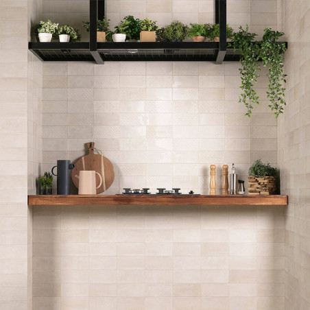 Weiße, rechteckige Wandfliesen bilden mit einem Holzregal eine Küchenkulisse. Auf dem Regal stehen Küchenutensilien und Gewürze 