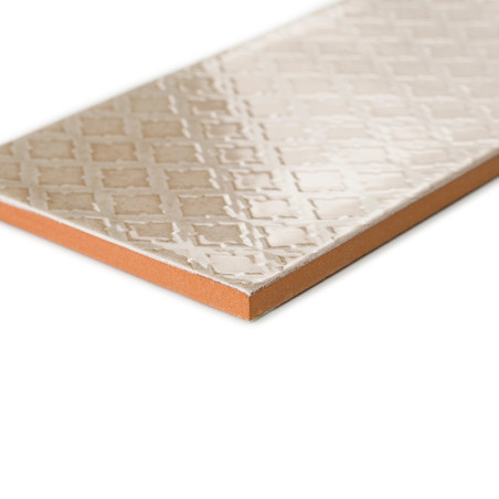 Eine rechteckige Keramikfliese mit geprägten geometrischen Mustern liegt auf einem weißen Hintergrund und hebt die beige glänzen