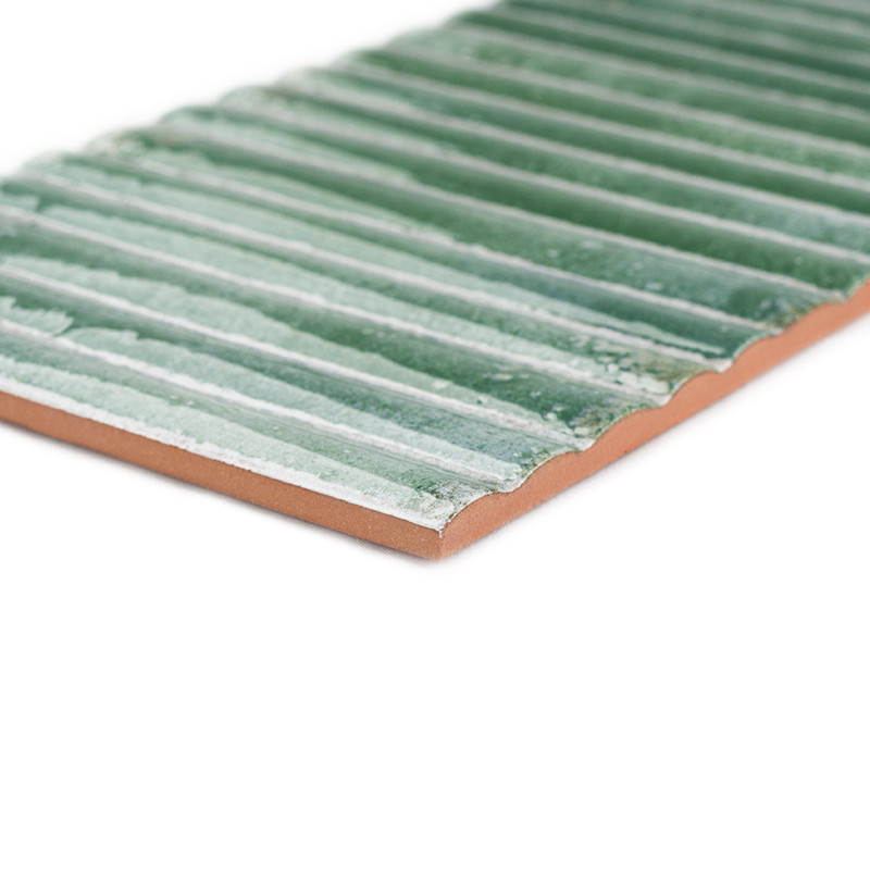 The tile features a ribbed, wavy pattern in a glazed green finish, adding texture. seen on a solid white background.