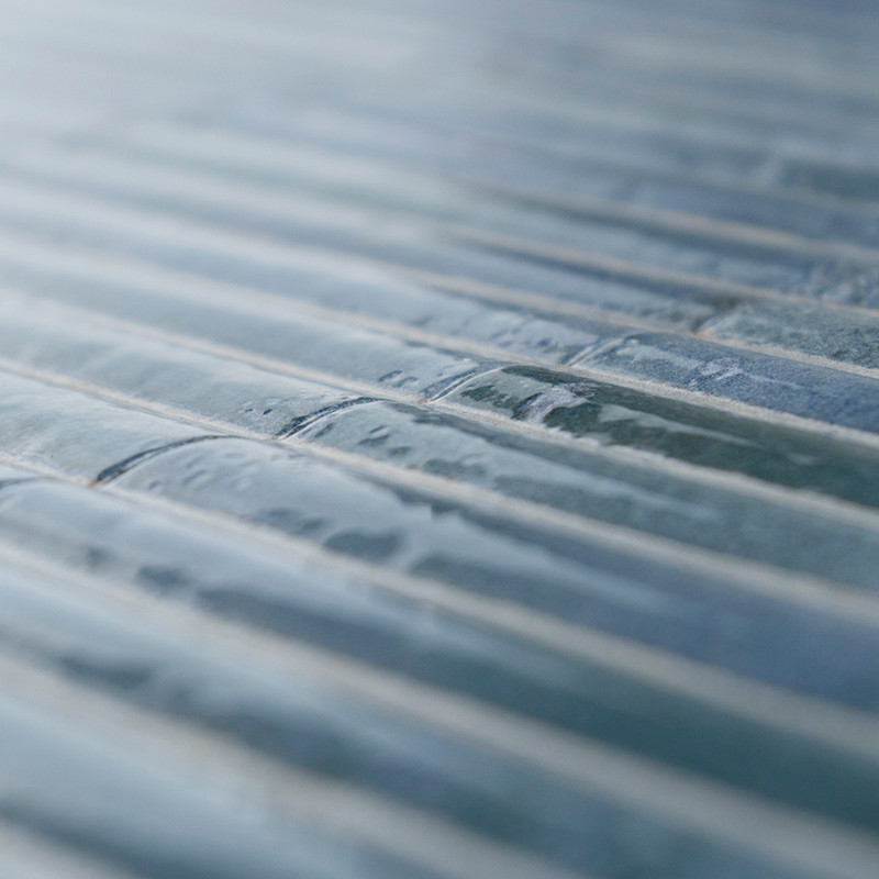 Im Mittelpunkt stehen strukturierte, rechteckige Glasfliesen, die in parallelen Reihen angeordnet sind. Das Licht wird sanft von