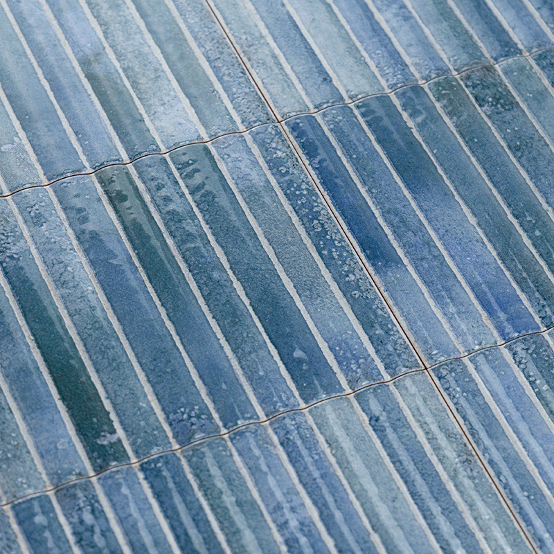 Blaue rechteckige Fliesen überlappen sich und erzeugen eine strukturierte Oberfläche. Dezente Farbvariationen und Glanz unterstr