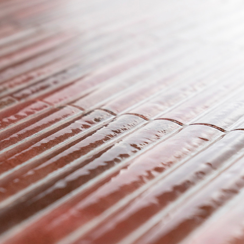 The tile surface features ridged, linear patterns creating a textured effect, reflecting light subtly in a calm indoor setting.