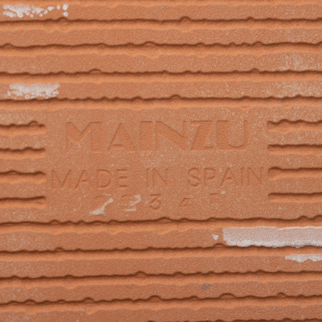 Auf der Terrakottafliese ist inmitten horizontaler Rillen der geprägte Text „MAINZU MADE IN SPAIN“ zu sehen, der auf Herkunft un Auf der Terrakottafliese ist inmitten horizontaler Rillen der geprägte Text „MAINZU MADE IN SPAIN“ zu sehen, der auf Herkunft un