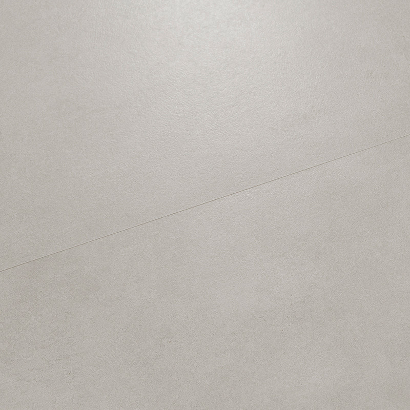 Un azulejo cerámico de color gris claro con acabado mate, que presenta una sutil línea diagonal, se coloca plano y sugiere una s