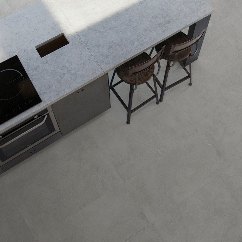 Uma ilha de cozinha minimalista apresenta uma bancada cinza com fogão integrado e uma área de estar com dois bancos de metal, si