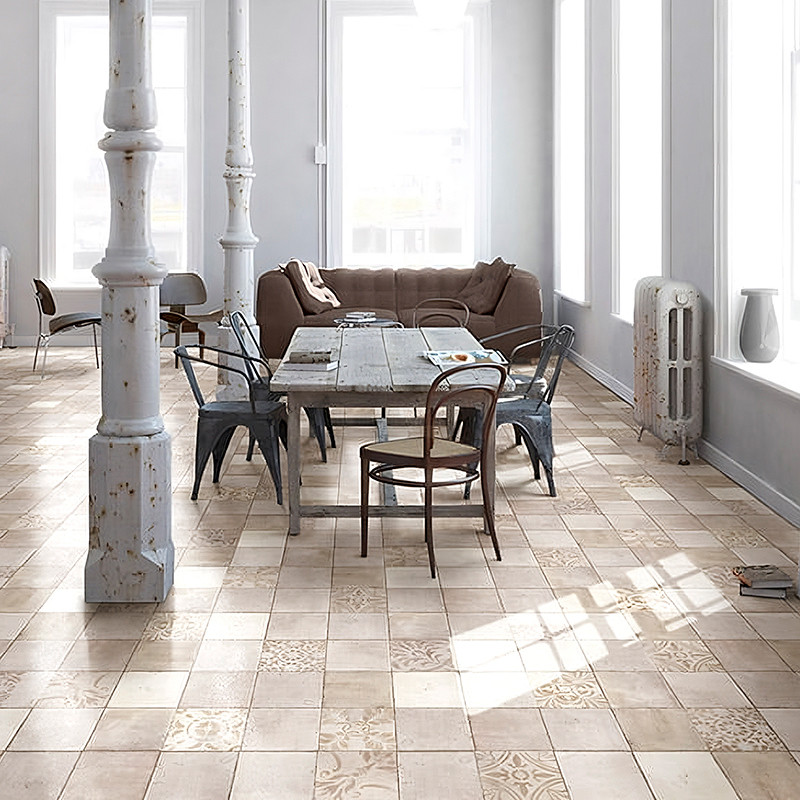 Uma mesa de jantar com cadeiras mistas assenta sobre azulejos bege estampados, cercada por colunas vintage e luz natural em uma 