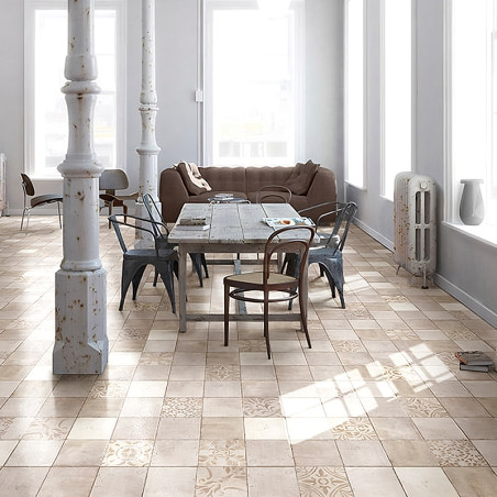 Une table à manger avec des chaises mixtes repose sur des carreaux beiges à motifs, entourée de colonnes vintage et de lumière n